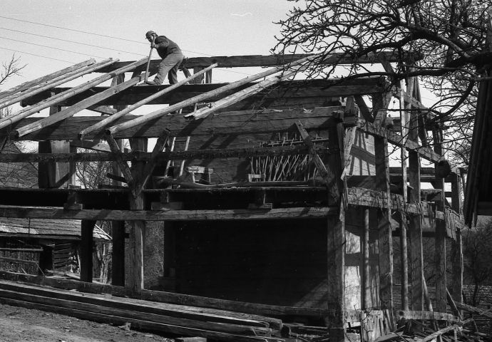 Bei der Abtragung in Voggenberg, 1984. Es steht nur mehr das eigentliche Gerüst. Das Dach ist bereits abgedeckt. Ein Mann ist daran, die Dachbalken zu lösen.