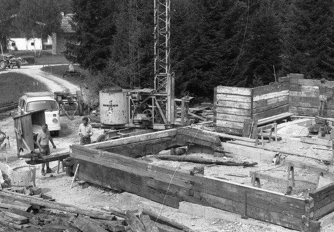 Beim Aufbau im Freilichtmuseum, 1984. Das Fundament ist gelegt und bis auf 1 Meter Höhe ist bereits der Wiederaufbau in Holz sichtbar.