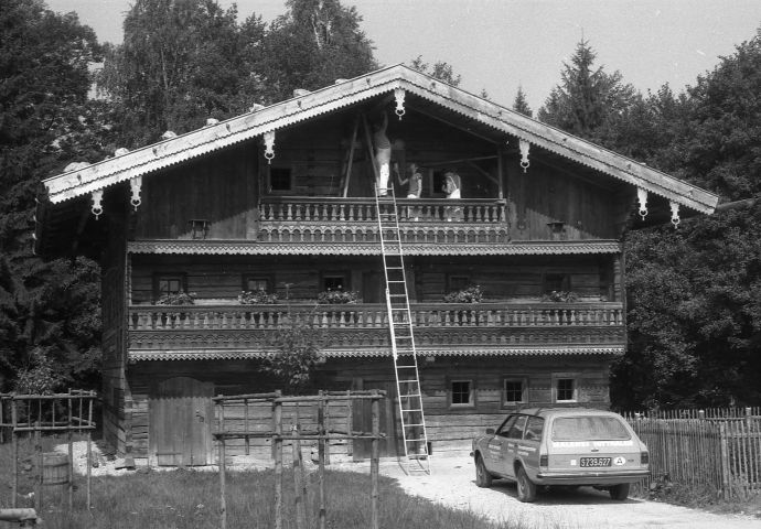 Malerarbeiten vor der Eröffnung, 1984. Der Maler steht auf dem balkon im zweiten Stockwerk und bemalt den First.