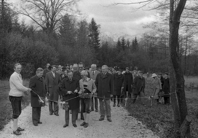 Bei der Firstfeier des Zischkhäusls, 1979. Blick vom Zischkhäusl Richtung Untersberg. Die Schnur wird gerade vom Ehrengast durchschnitten. Kurt Conrad steht rechts. Im Hintergrund sind die Gäste zu sehen.